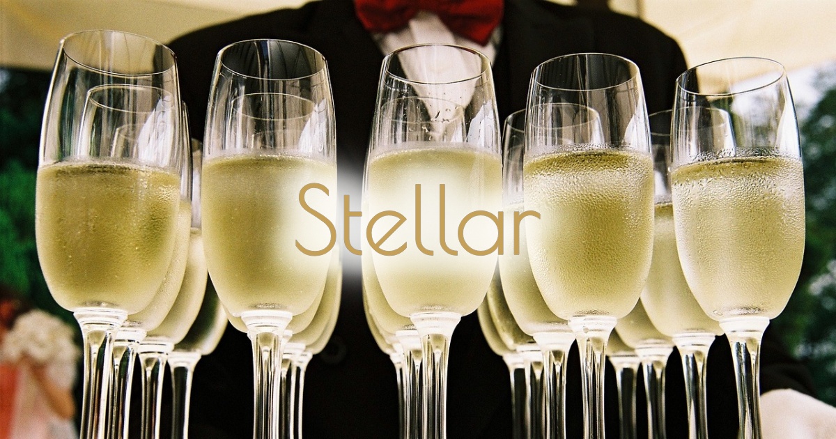 Champagne glasses celebrating the 7th anniversary of Stellar Immigration Consultancy, featuring the "Stellar" logo in gold.